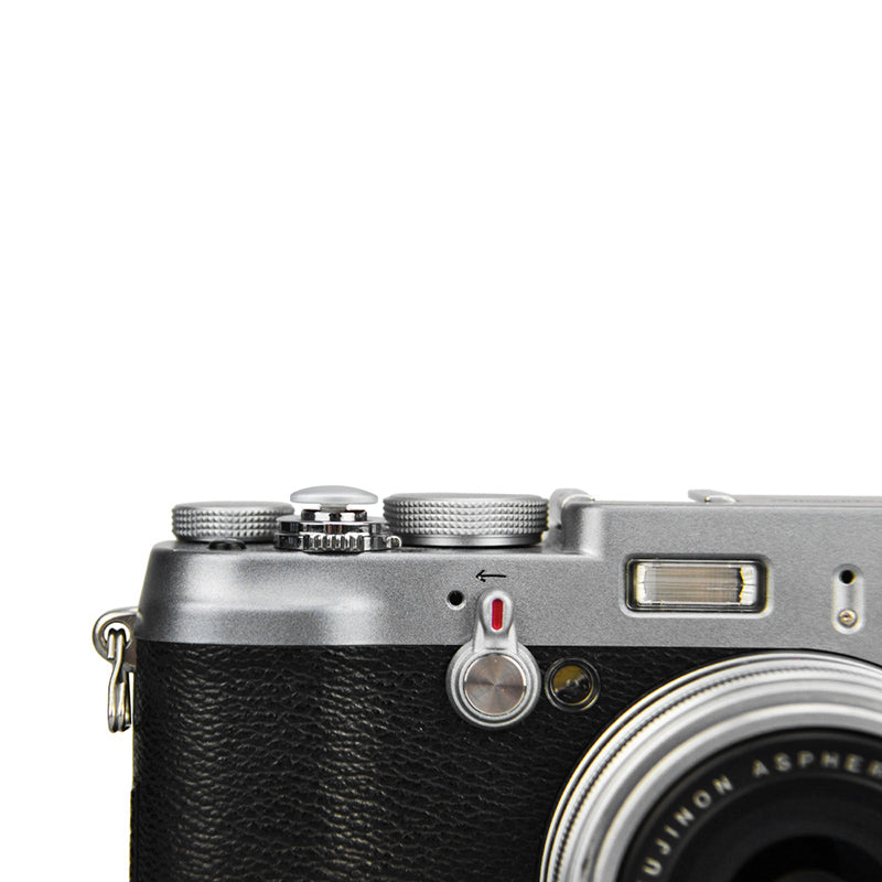 A close-up of a JJC silver soft release button attached to a camera body.