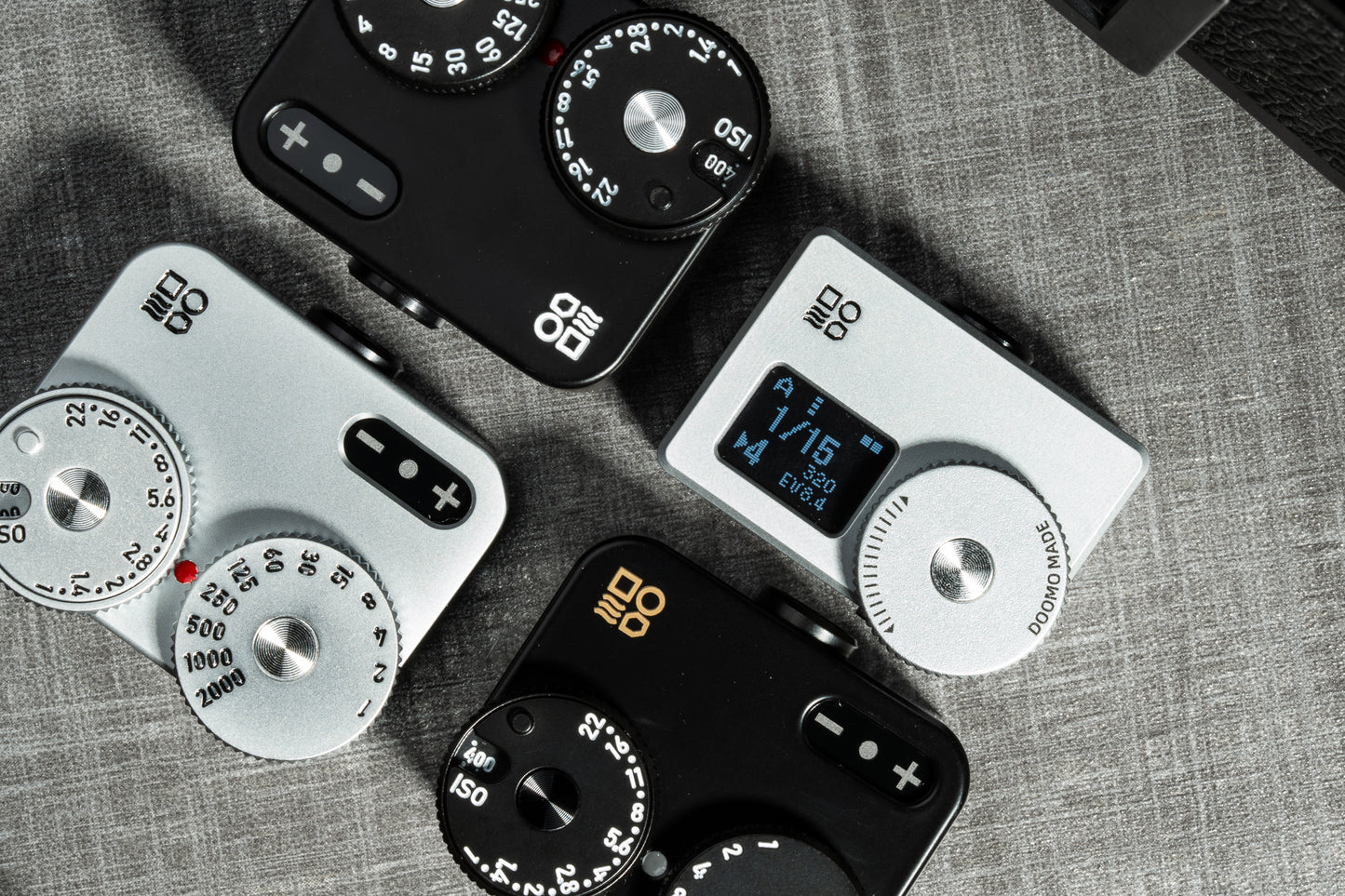 A close-up shot of several Doomo Meter D hot shoe light meters on a table.
