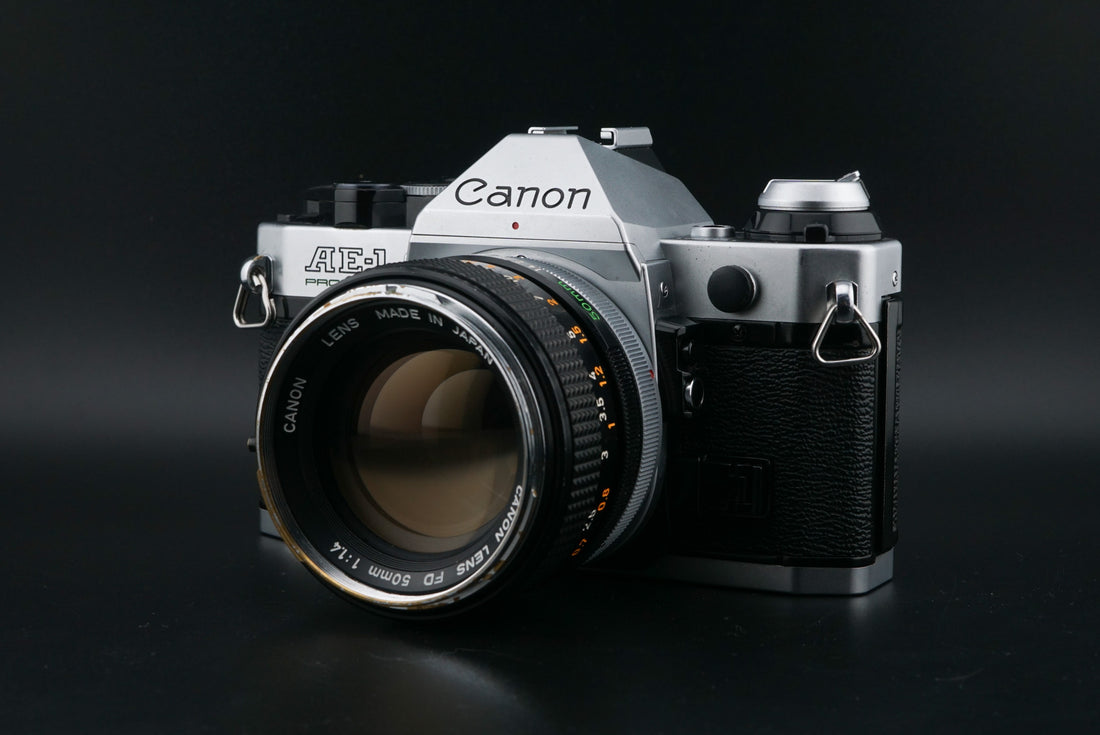 Canon AE-1 Program film camera with 50mm f1.4 lens on a black background