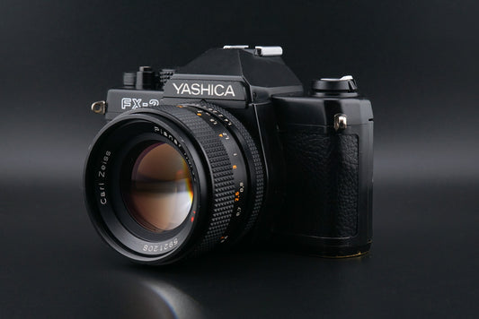 Black Yashica FX-3 film camera on a black background