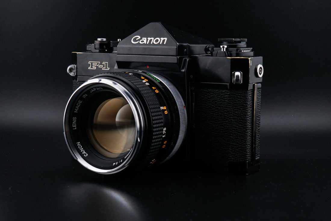 Black Canon F-1 film camera on a black background