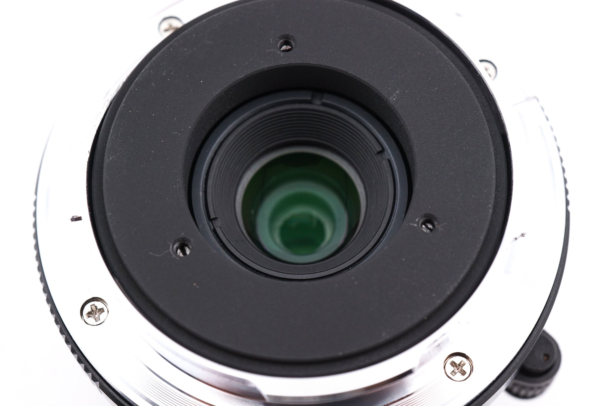 A close-up of 7Artisans 28mm lens rear on a white background.