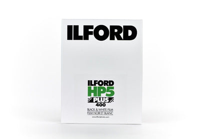 An Ilford HP5 Plus 400 black and white film on a white background. 4x5", 25 Sheets. 