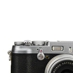 A close-up of a JJC silver soft release button attached to a camera body.