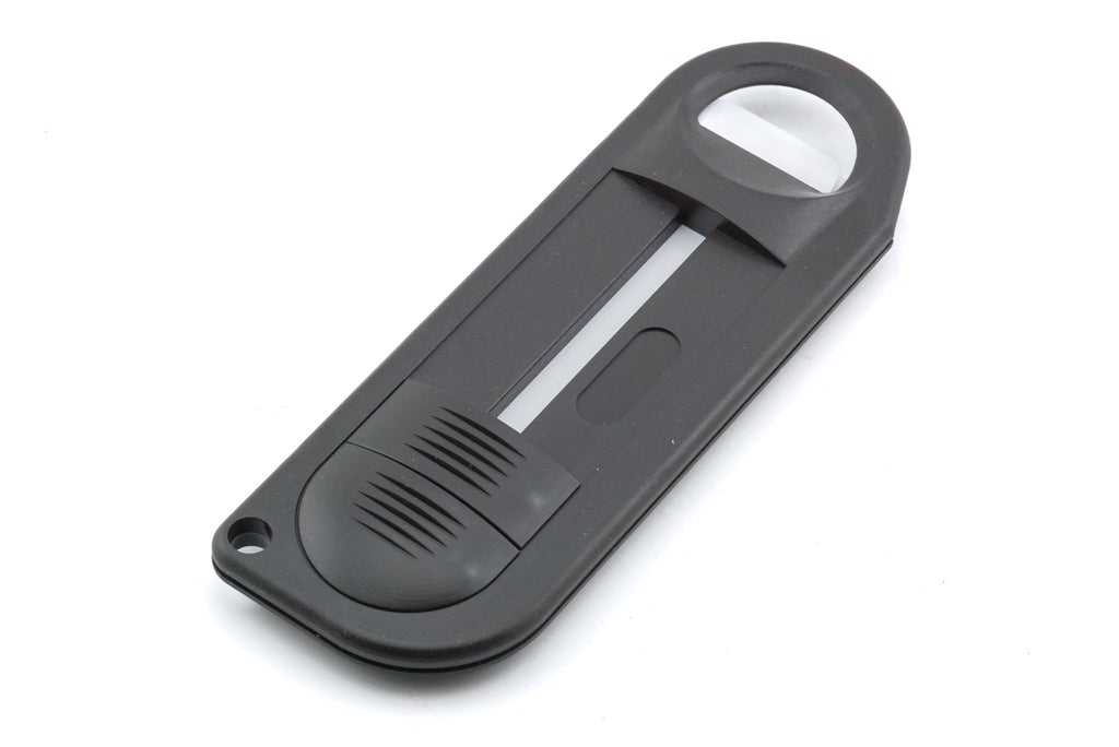A close-up of a handheld plastic device on a white background. For 35mm film canister.