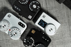 A close-up shot of several Doomo Meter D hot shoe light meters on a table. 