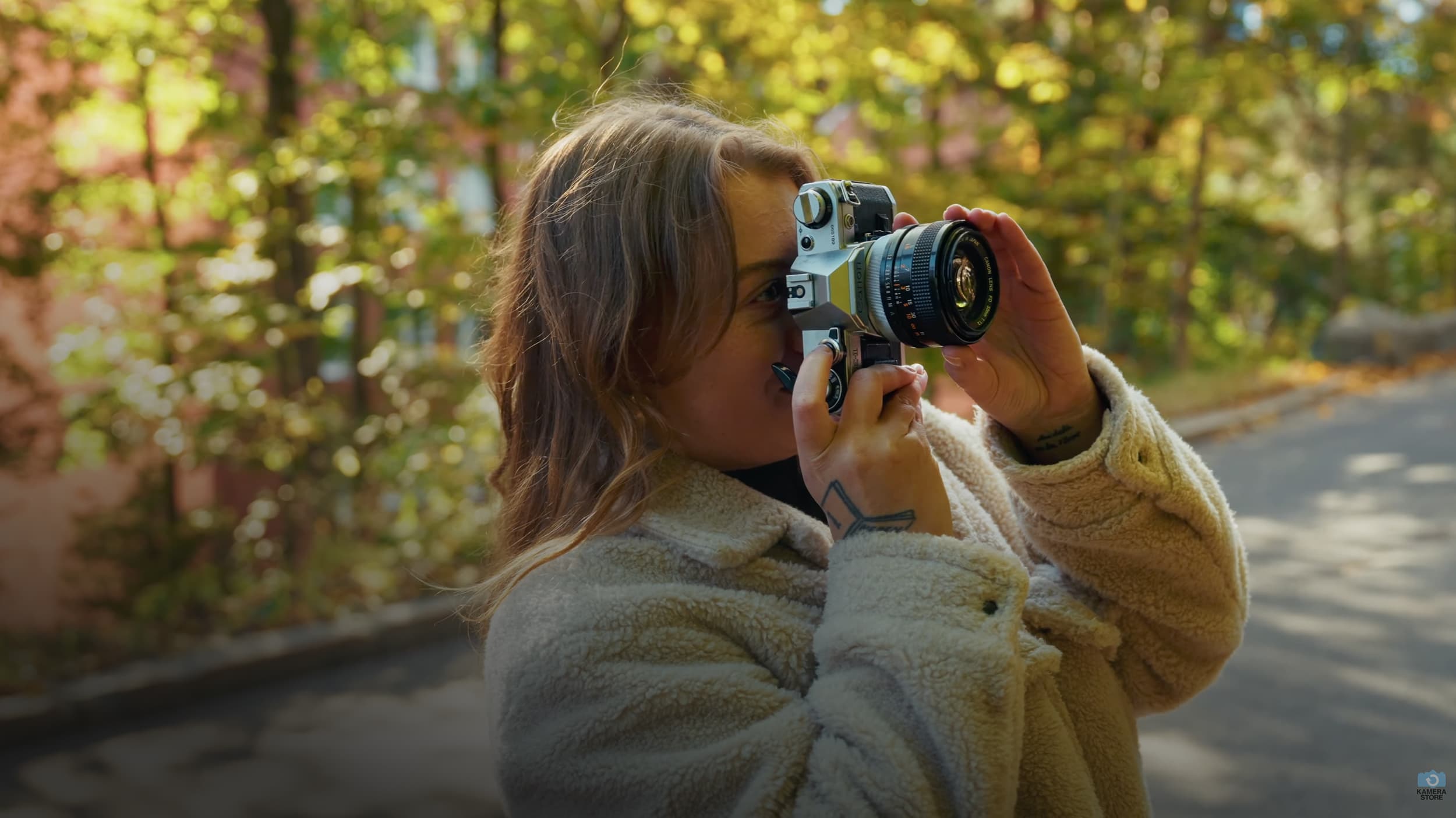 Person taking a photo with a camera in an outdoor setting