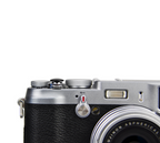 A close-up of a black JJC soft release button attached to a camera body.