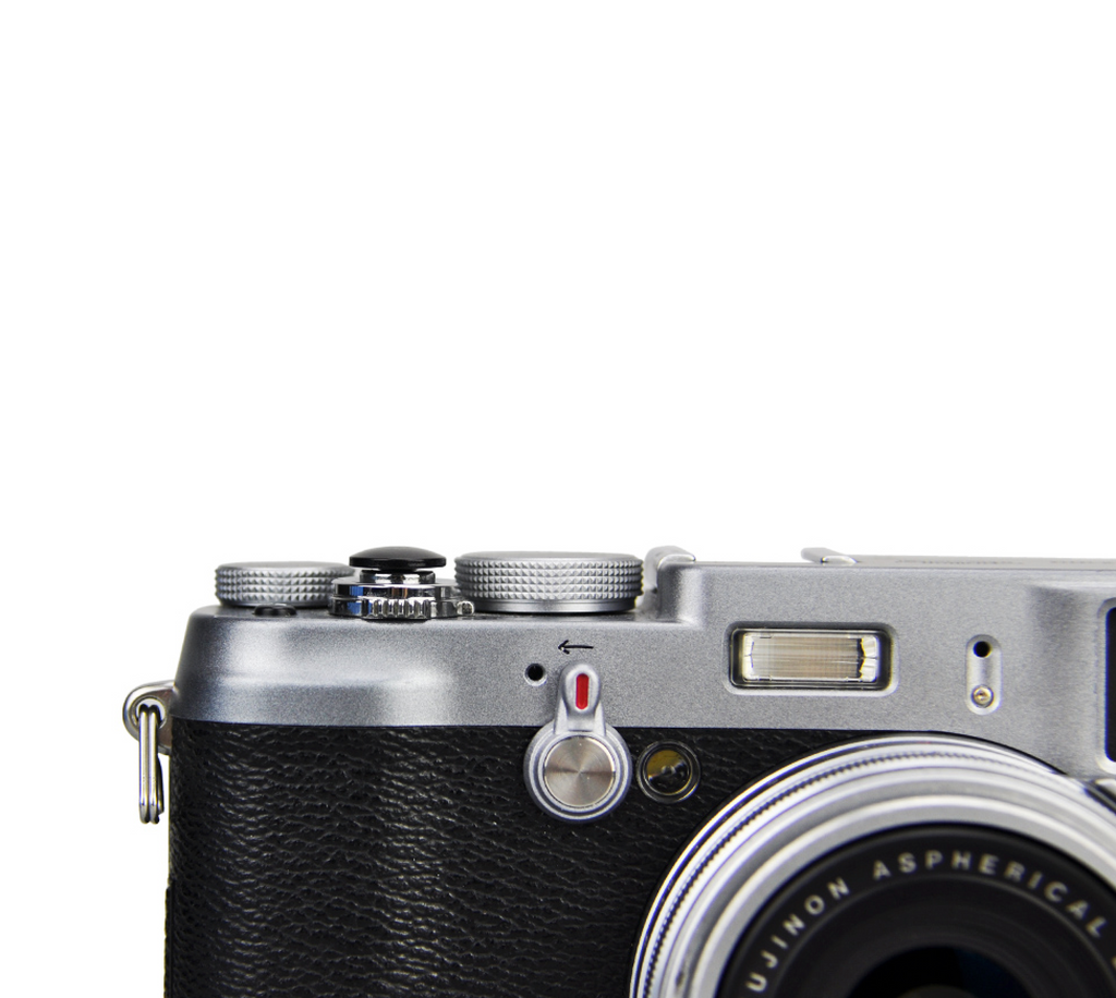 A close-up of a black JJC soft release button attached to a camera body.