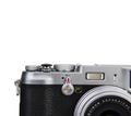 A close-up of a black JJC soft release button attached to a camera body.