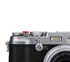 A close-up of a red JJC soft release button attached to a camera body.