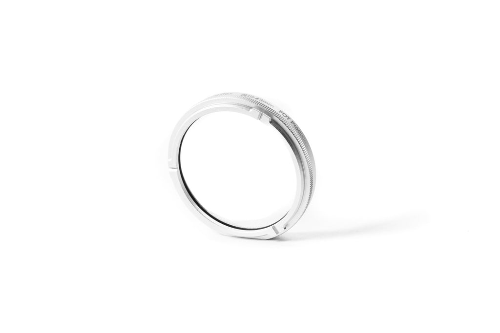 A close-up of 43mm metal adapter on a white background.