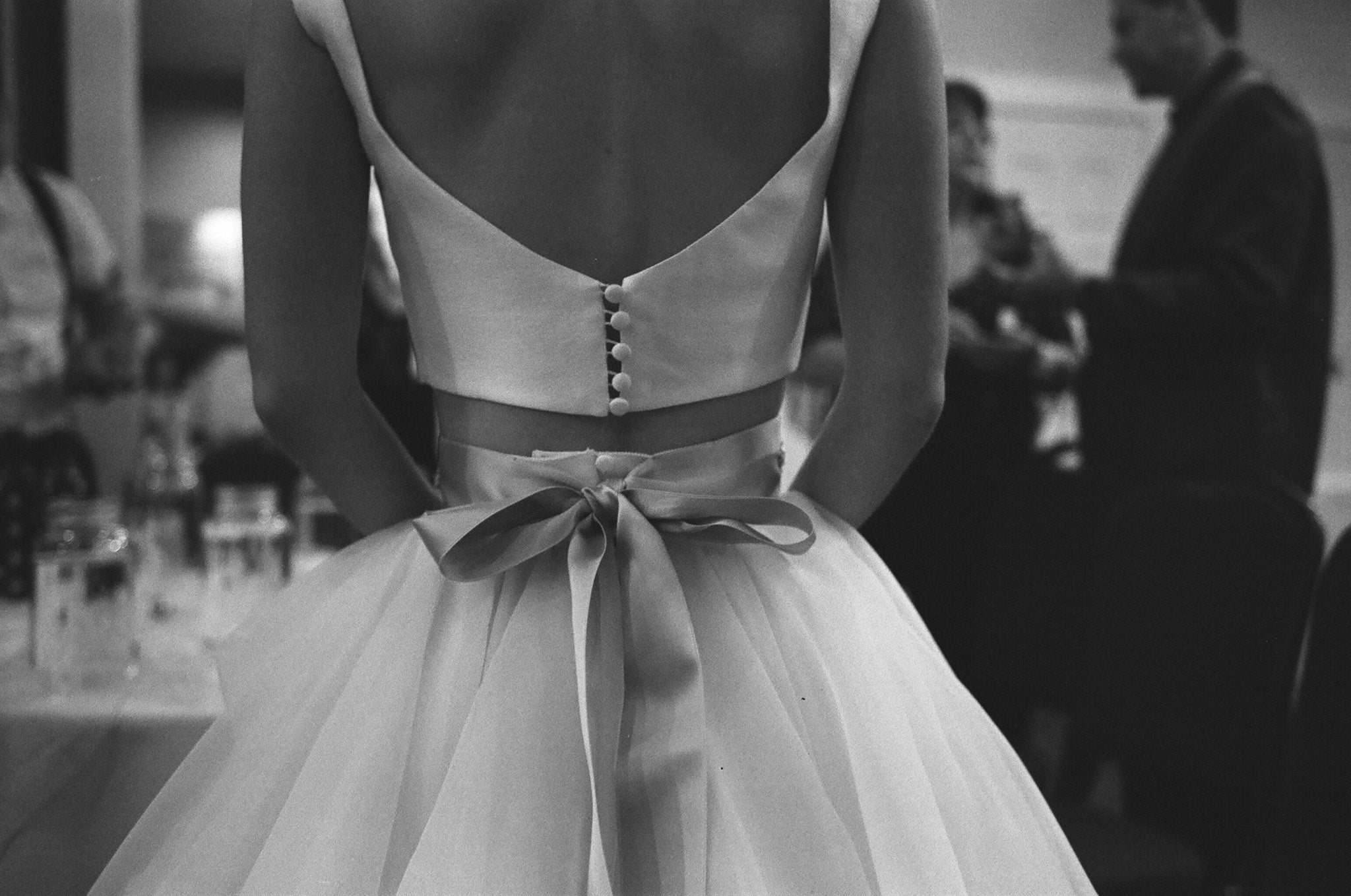 A black and white photo of a bride wearing a wedding dress in a wedding party.  