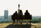 People sitting on a bench with a city skyline on the background. Kodak Gold 200.
