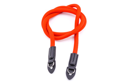 A red rope camera strap on a white background.