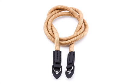 A beige rope camera strap on a white background.