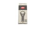 A metal film canister opener in a package on a white background. For 35mm canisters.