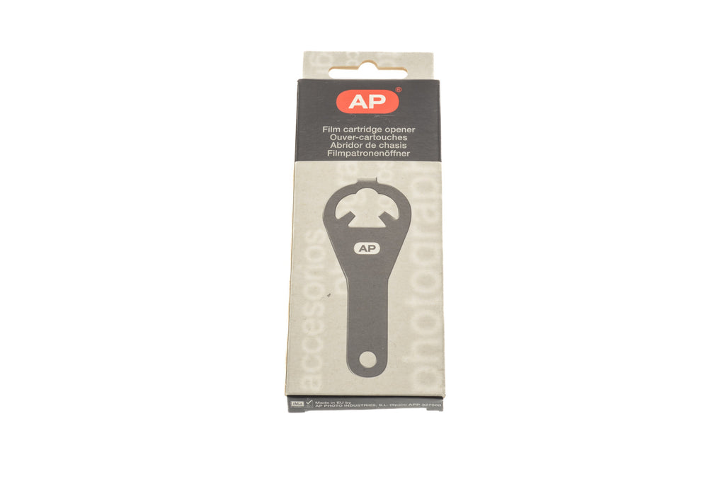 A metal film canister opener in a package on a white background. For 35mm canisters.