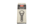 A metal film canister opener in a package on a white background. For 35mm canisters.