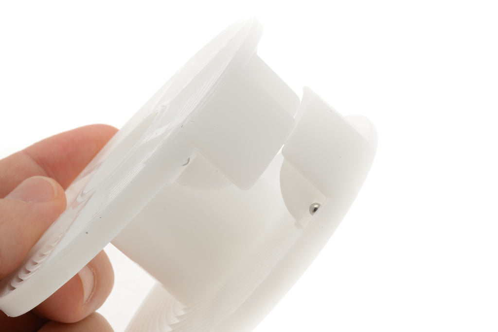 A close-up of a plastic reel film developer on a white background. 
