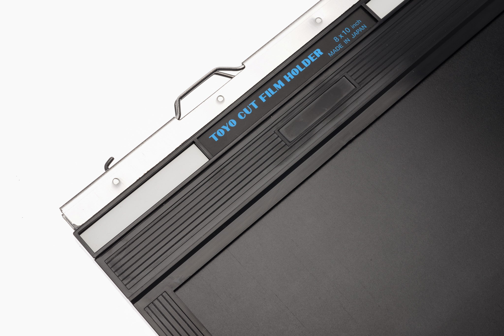 A close-up of a film holder on a white background. Toyo 8x10".